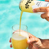 Piña Colado Smooj poured into a clear glass in front of a swimming pool.